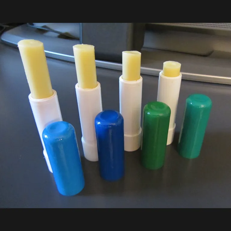 Original photo: four homemade lip balms with coloured caps on a desk