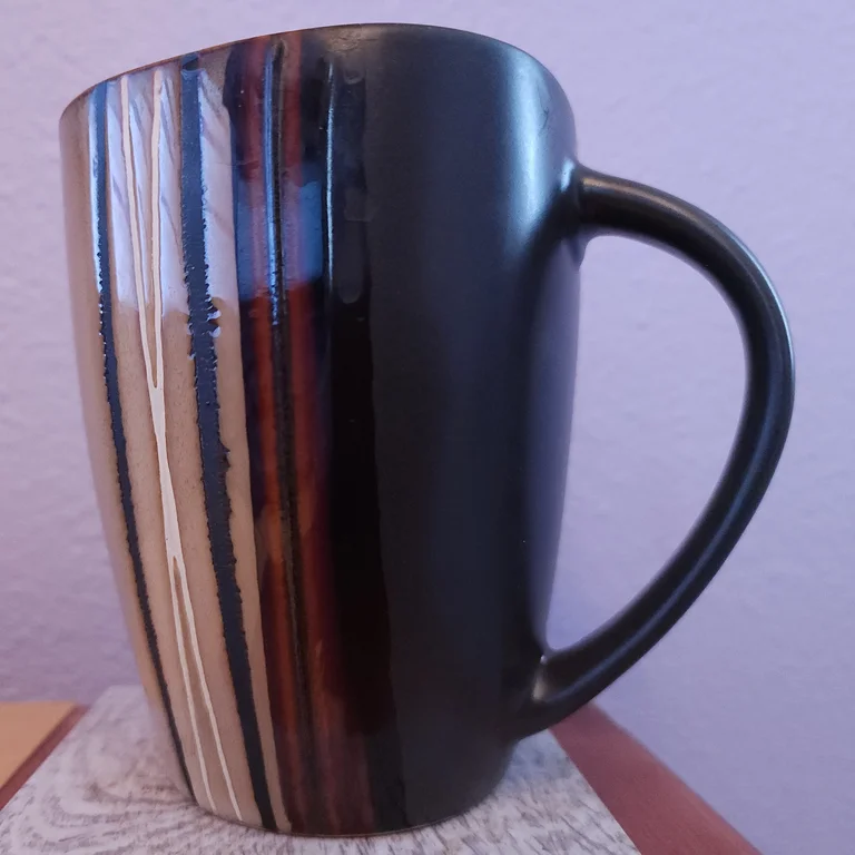 Original photo: a striped coffee mug on a cluttered shelf