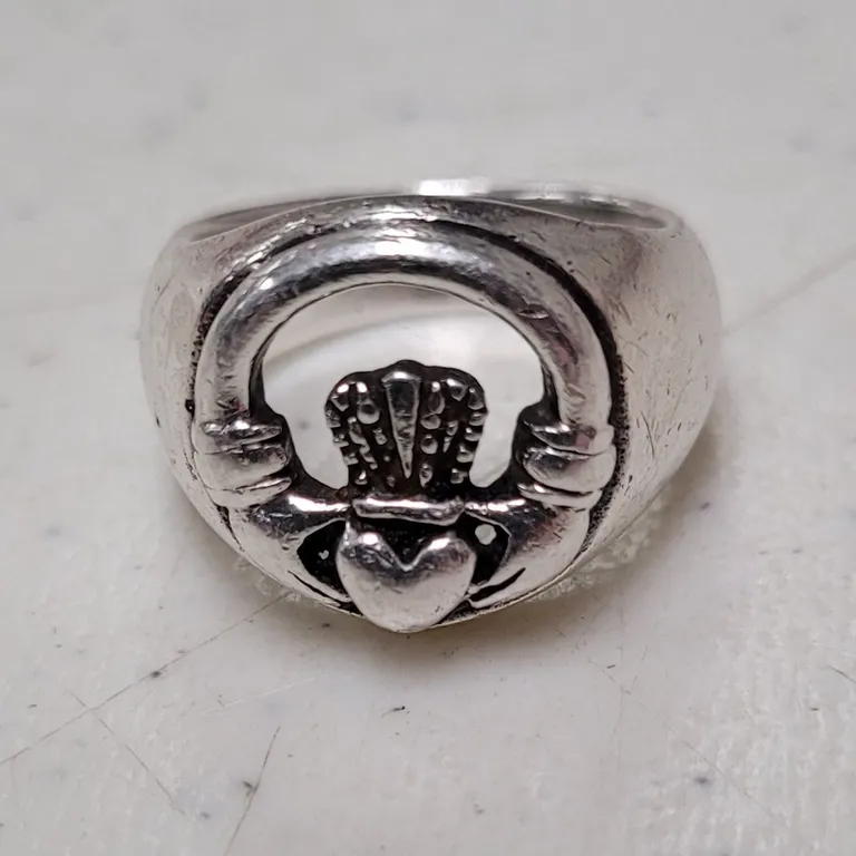 Original photo: a silver Claddagh ring on a scuffed white surface