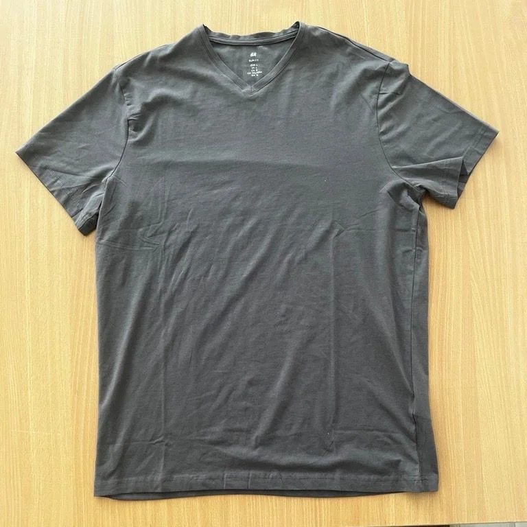 Original photo: a grey V-neck t-shirt laid on a wooden table